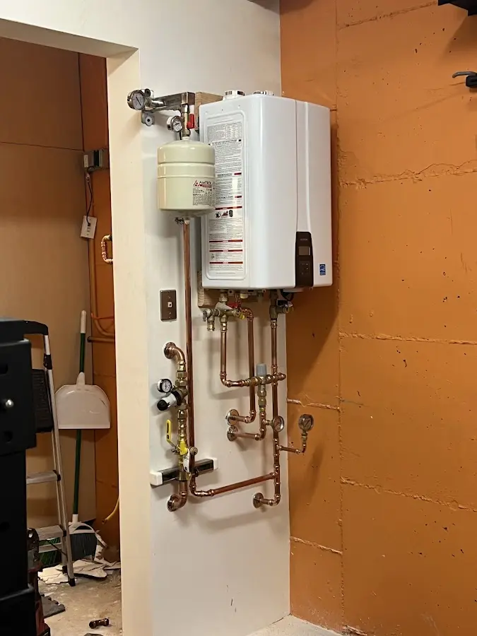 Plumbing technician inspecting water heater connections in Alpine